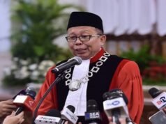 El juez del Tribunal Constitucional Arsul Sani muestra su diploma de doctorado original