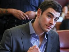 Luigi Mangione, sospechoso de asesinato vestido, levanta el puño mientras brilla durante la audiencia judicial