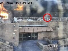 Momento en el que un pirómano inicia un incendio de ₤ 50 000 y luego se sienta tranquilamente y fuma un cigarrillo mientras el edificio arde detrás de él.