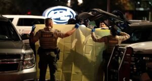 La policía de Nancy Guthrie sostiene una sábana mientras retiran artículos del Array Vagabond después de detener a un hombre en el estacionamiento de un restaurante.